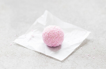 Pink "Raffaello". Strawberry mousse cream dessert,  sprinkled with coconut chips. On paper. Light background