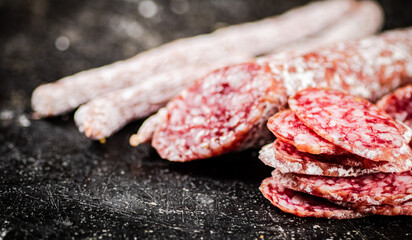 Sliced delicious salami sausage. On a black background.