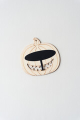 wooden pumpkin or jack o lantern ornament with black paper oval mask and big smile