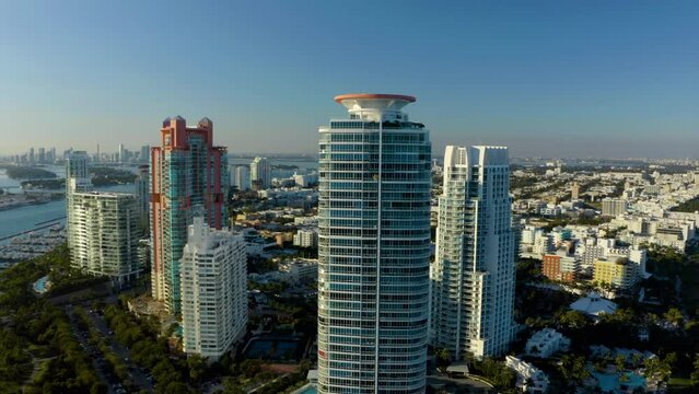 Aerial panoramic view of high rise buildings along sea coast. Modern city borough with hotels and vacation resorts. Miami. Fly over stripe of high rise buildings along sea coast. High rise apartment. 