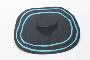 abstract black paper circle with two blue lines and a paper moustache 
