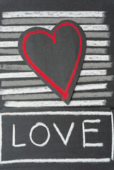 paper heart with red outline on a striped background with the word "love"