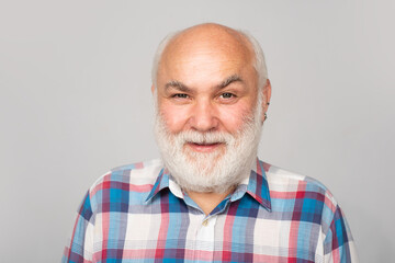 Obraz premium Older grandfather, grandpa pensioner, retiree concept. Portrait of an mature senior man with grey beard isolated on studio background.