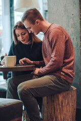 Man and woman drinking coffee in a cafe. Two people, man and woman in cafe communicate, laughing and enjoying the time spending with each other. Couple in love on a date. Love story and Valentines Day