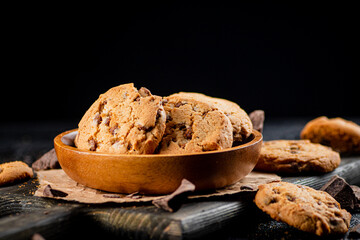 Cookies with pieces of milk chocolate on a cutting board. 