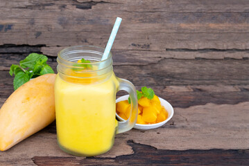 Mango juice fruit smoothies yogurt drink yellow healthy delicious taste in a glass slush for weight loss on wooden background.