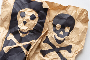 two skull and crossbones on crumpled paper