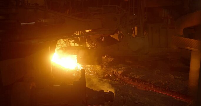 Metal casting process in metallurgical plant. Liquid metal pouring into molds