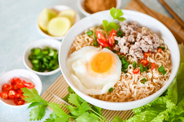 noodles bowl with boiled egg minced pork vegetable spring onion lemon lime lettuce celery and chili on table food , instant noodles cooking tasty eating with bowl - noodle soup