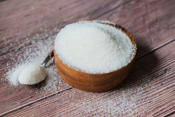 Sugar on wooden bowl and spoon background, white sugar for food and sweets dessert candy heap of sweet sugar crystalline granulated