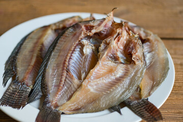 dried fish on white plate, tilapia fish for cooking food on wooden - food preservation dry fish