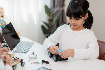 Asia students learn at home in coding robot cars and electronic board cables in STEM, STEAM, mathematics engineering science technology computer code in robotics for kids concept.