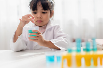 education, science, chemistry and children concept - kids or students with test tube making experiment at school laboratory