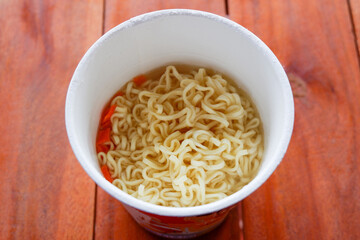 instant noodles boiled , cook instant ramen noodles in a cup - noodle soup on paper bowl