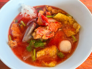 Food Thai style noodle with assorted tofu and fish ball in red soup - Asian food style pink seafood flat noodles on soup bowl