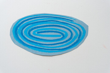 round or ovoid construction paper shape with abstract spiral lines in blue