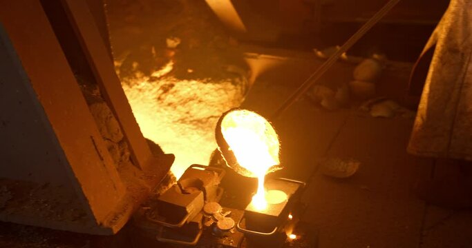 Metal casting process in metallurgical plant. Liquid metal pouring into molds
