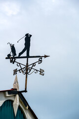 Silhouette of a weathervane representing a golfer, close up - obrazy, fototapety, plakaty