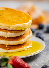Pancakes in a plate with berries and honey. 