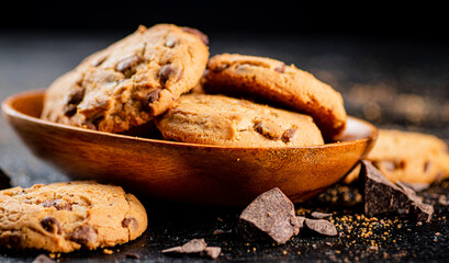 Wooden plate with cookies and pieces of milk chocolate. 