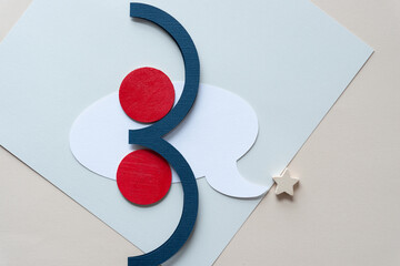 abstract composition with wooden star object, white paper speech bubble, round circles painted red,...