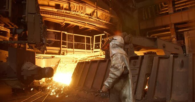Metal casting process in metallurgical plant. Liquid metal pouring into molds