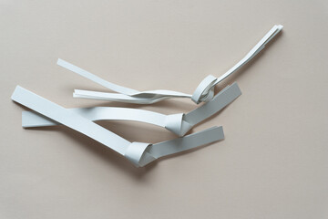 knotted paper stripes on blank paper