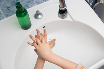 boy washing his hands after coming from playing. coronavirus