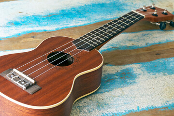 Obraz premium Ukulele, a small Hawaiian guitar, on rustic board