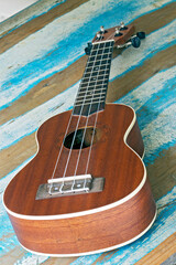 Obraz premium Ukulele, a small Hawaiian guitar, on rustic board