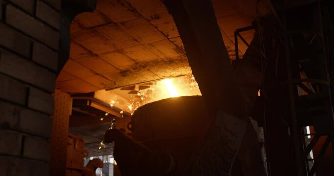 Metal casting process in metallurgical plant. Liquid metal pouring into molds