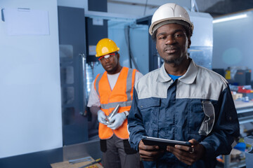 Happy Industry portrait of african engineer holding tablet, background blue power plant control room