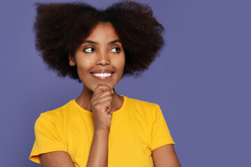 Fototapeta na wymiar Portrait of smiling African American woman on purple background. Space for text