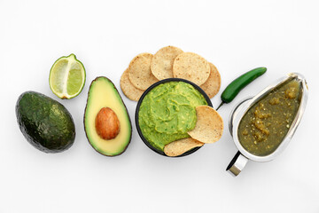 Delicious guacamole made of avocados, nachos and green pepper on white background, top view