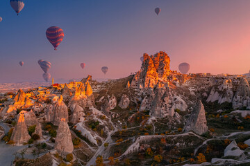 Fototapeta premium Goreme national park, Ancient Uchisar castle with colorful hot air balloons at sunset , Cappadocia Turkey