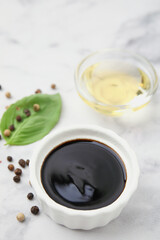 Bowl with balsamic vinegar on white table