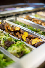 Grilled roasted fingerling potatoes in a container at a salad and food bar.