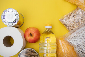 Donations food with canned food on yellow background, canned goods and dry food non perishable with cooking oil, donate concept,