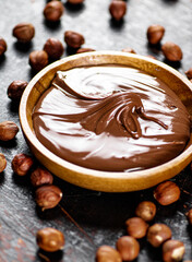 Hazelnut butter with peeled hazelnuts on the table. 