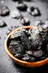 Prunes in a wooden plate on the table. 