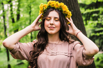 Fashion Summer Model Girl with Long Blowing Hair. Summer Beautiful Woman with Healthy and Beauty Brown Hair with Green Grass on Sunny Background