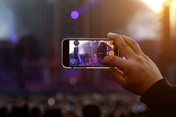 Taking photos of a rock concert on the mobile phone, open-air festival.