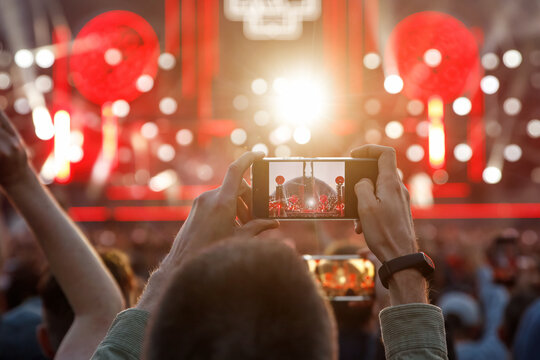 Making photos and videos of the outdoor summer concert via smartphone.
