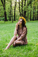 Fashion Summer Model Girl with Long Blowing Hair. Summer Beautiful Woman with Healthy and Beauty Brown Hair with Green Grass on Sunny Background