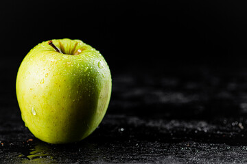 One fresh green apple on the table. 