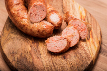 salmon sausage, On a wooden textured background wooden cutting Board with on which salmon sausage grilled. Top view macro.