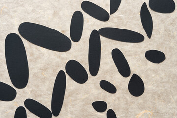 grungy cut paper shapes (mostly oval or ovoid) arranged diagonally (somewhat) on textured tissue paper 