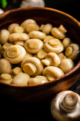 Homemade pickled mushrooms in a wooden bowl. 