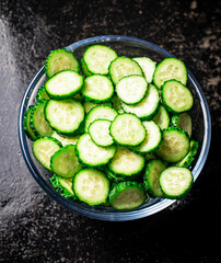 Full glass bowl of chopped fresh cucumbers. 