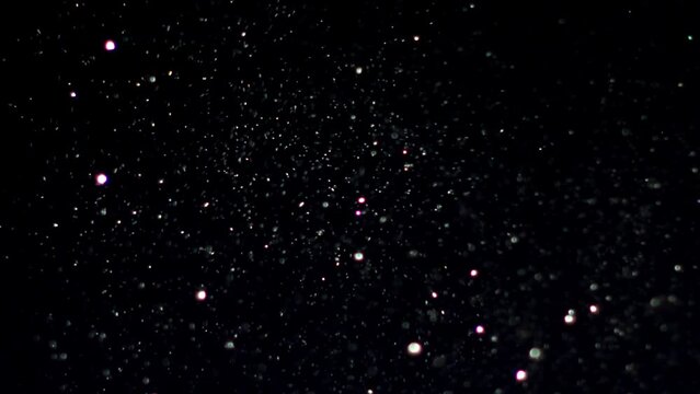 4k Natural Organic Dust Particles Floating On Black Background, Light colorful particles in slow motion, Brocade Effect high quality, glowing and shining particles spread in air, wind moving particles